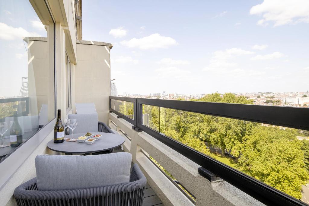 a balcony with two chairs and a table and a window at Hotel Barsey by Warwick in Brussels