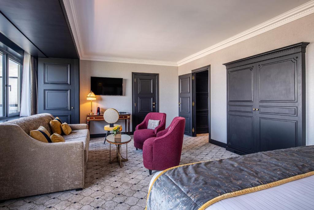 a hotel room with a bed and a couch and chairs at Hotel Barsey by Warwick in Brussels