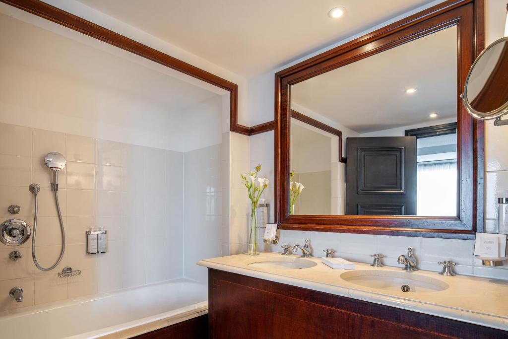 a bathroom with two sinks and a large mirror at Hotel Barsey by Warwick in Brussels