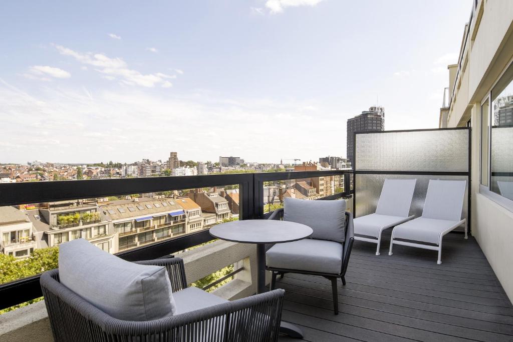 a balcony with chairs and a table on a building at Hotel Barsey by Warwick in Brussels