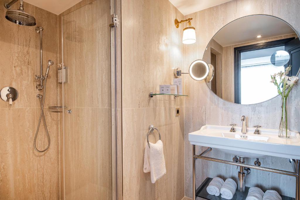 a bathroom with a shower and a sink and a mirror at Hotel Barsey by Warwick in Brussels