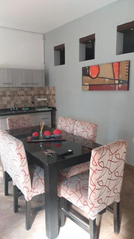 a dining room with a black table and two chairs at departamento del centro in La Falda