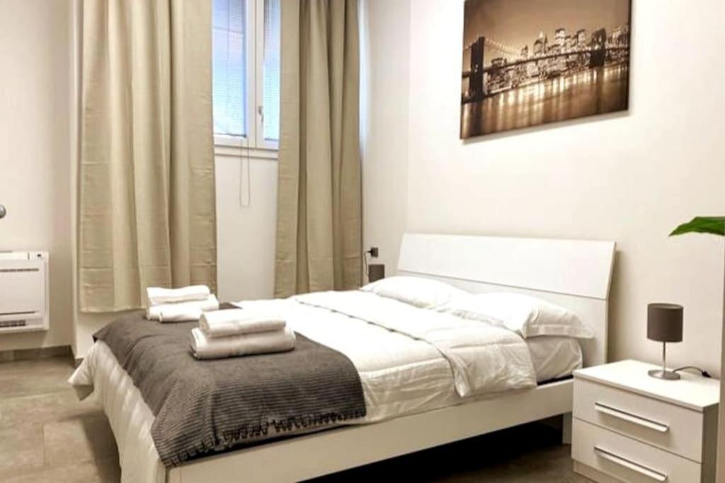 une chambre avec un grand lit blanc avec des serviettes dessus dans l'établissement Reno Apartment, à Casalecchio di Reno