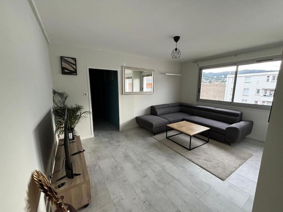 un salon avec un canapé et une table dans l'établissement Hyper-centre Ville avec Parking, à Clermont-Ferrand