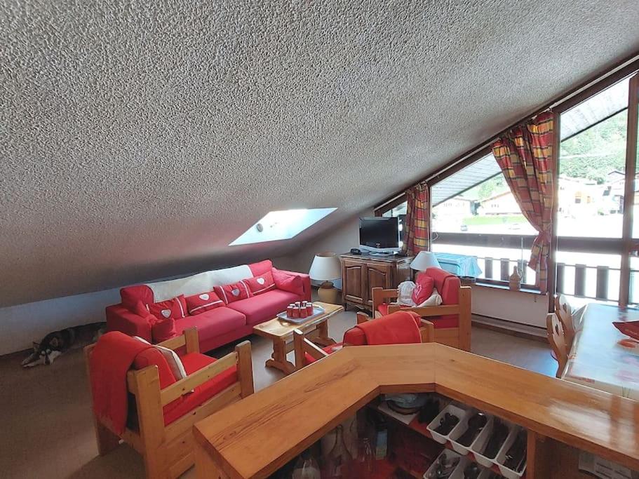 un salon avec des canapés rouges et une table dans l'établissement Les Appartements Diochon, à Le Baplieu