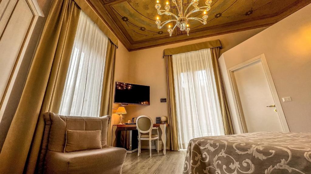 a bedroom with a bed and a chair and a desk at Hotel Genova Liberty in Genoa