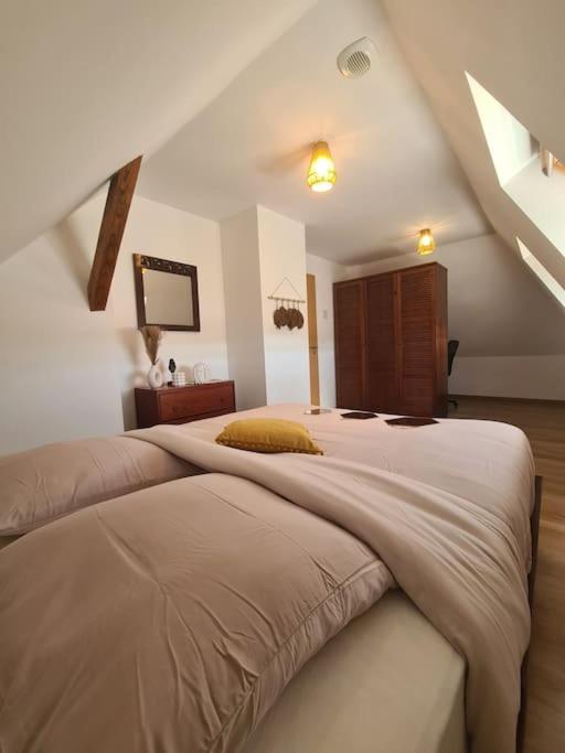 une chambre avec un grand lit dans un grenier dans l'établissement Bienvenue chez Angèle homes 3, à Niederbronn-les-Bains