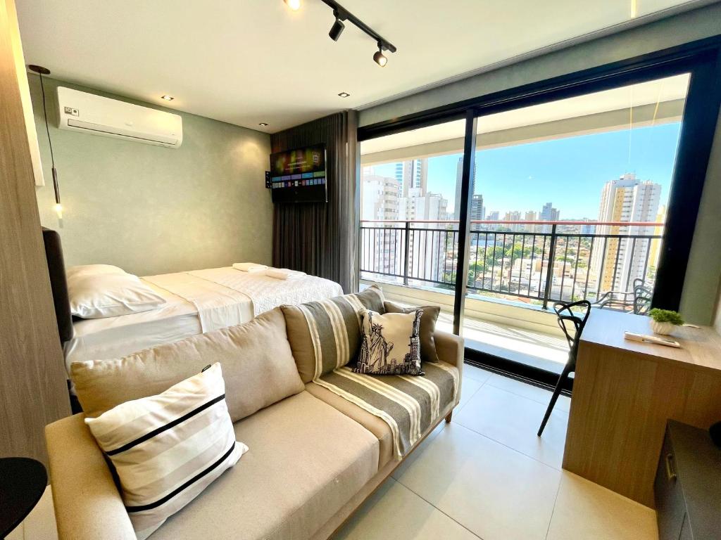 a living room with a couch and a large window at A Melhor Vista com Academia no Rooftop in Campo Grande