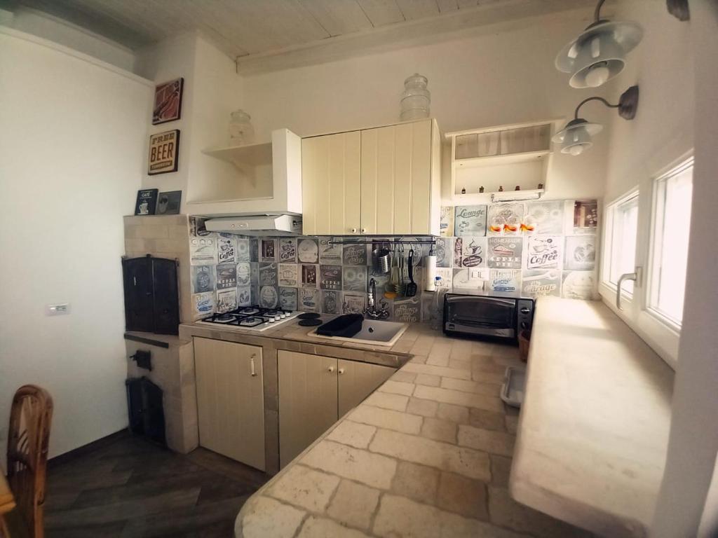 a kitchen with white cabinets and a counter top at Le case di Roberto in Gioia del Colle