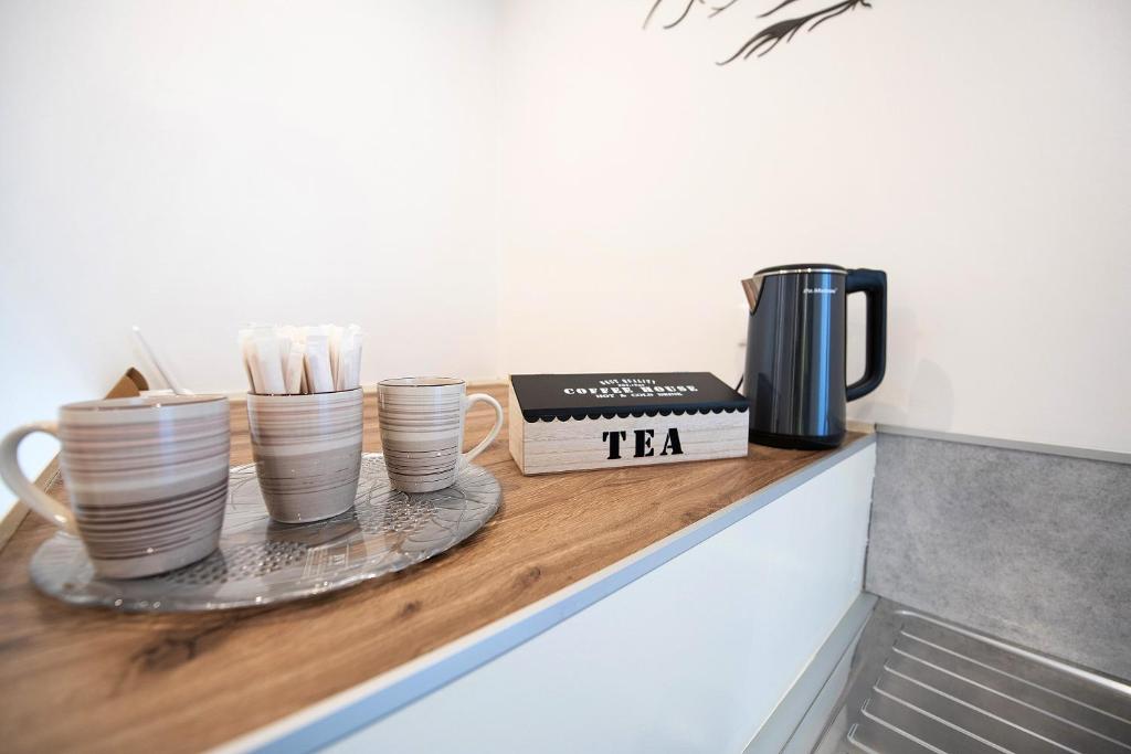 een toonbank met kopjes en een theedoos erop bij affittacamere Ke vita Rooms Salò in Soprazocco