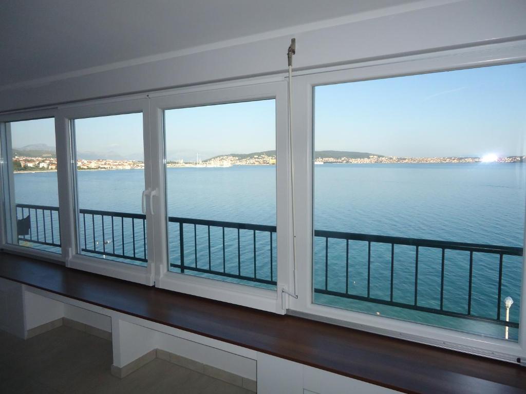 una camera con tre finestre che si affacciano sull'acqua di Holiday Home Sisko a Trogir