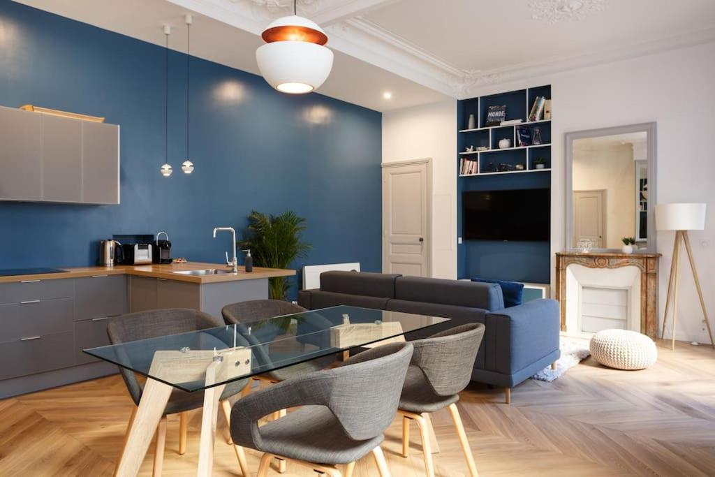 une cuisine et un salon avec une table et des chaises dans l'établissement Renovated spacious Parisian apt near la Madeleine, à Paris