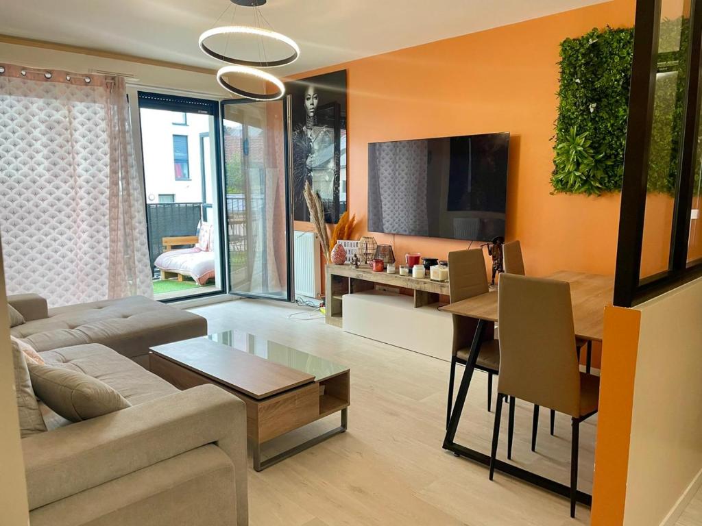 a living room with a couch and a table at Appartement Cosy in Saint-Gratien