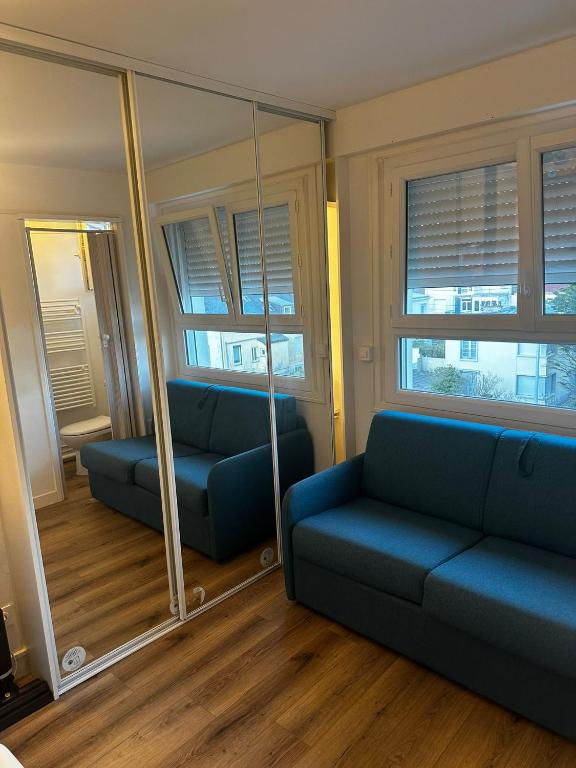 un salon avec un canapé et un miroir dans l'établissement L'ancre marine, à Berck-sur-Mer