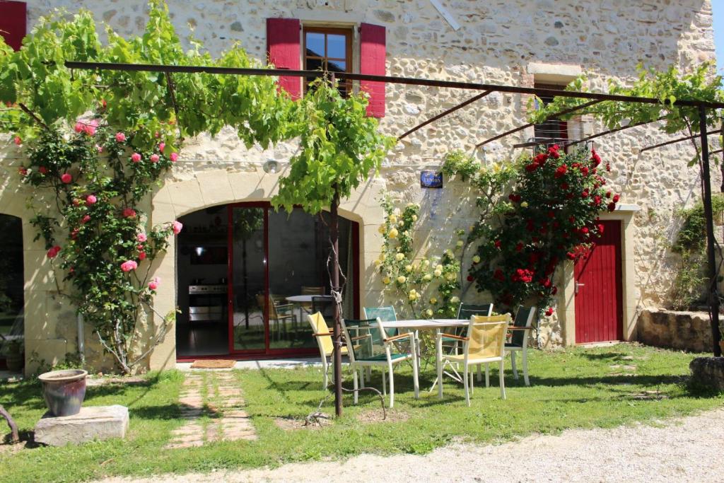 a patio with a table and chairs in front of a building at Chez Germaine in Les Granges-Gontardes