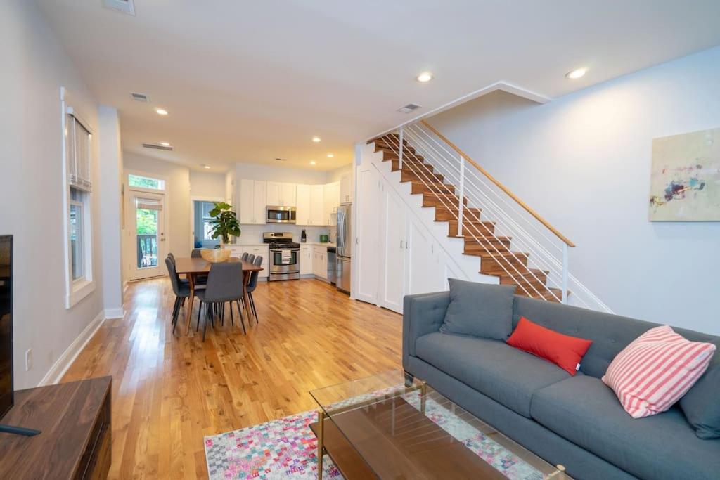 a living room with a blue couch and a staircase at Modern 4BR Columbia Heights Gem Walk 2 Metro & Shops in Washington