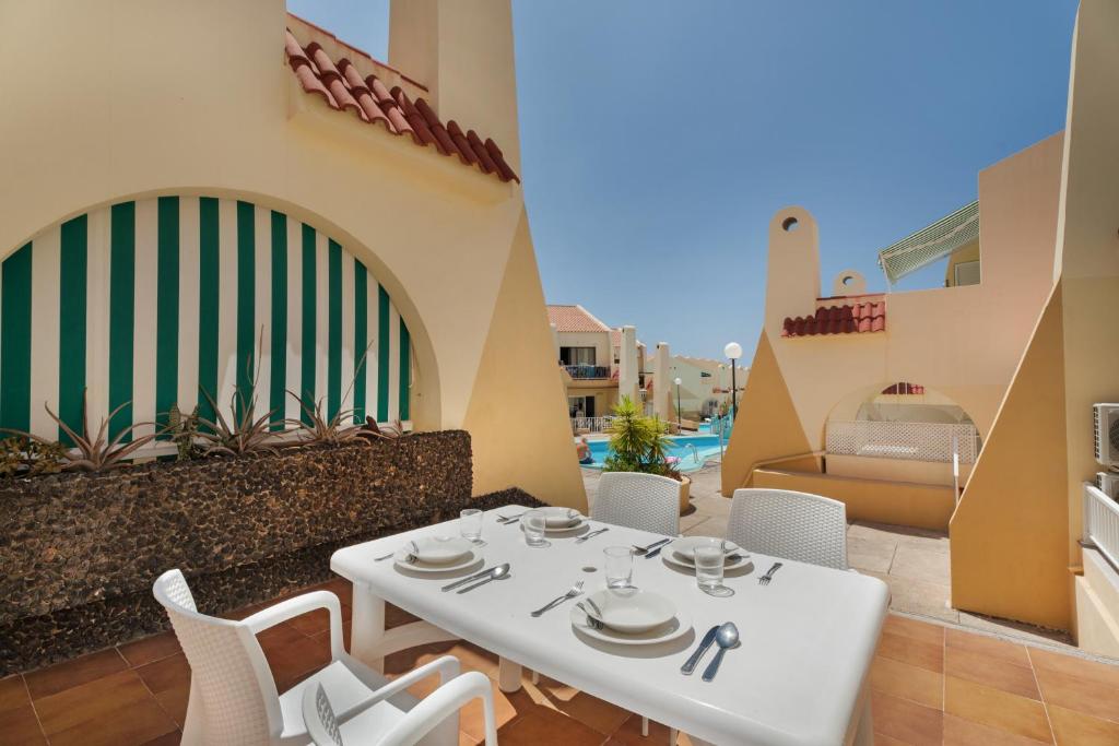 a white table and chairs on a balcony at Beach Holidays in Adeje