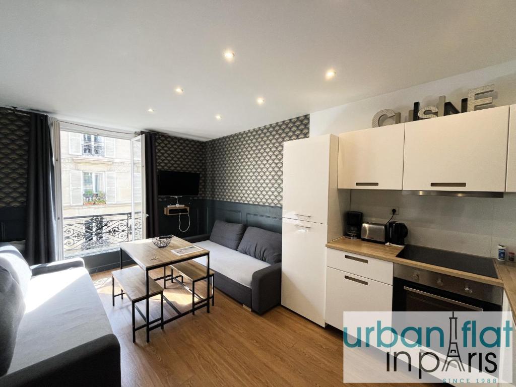 un salon avec un canapé et une table dans l'établissement Urban Flat 18 - Charming 2BDR Parisian Home, à Paris