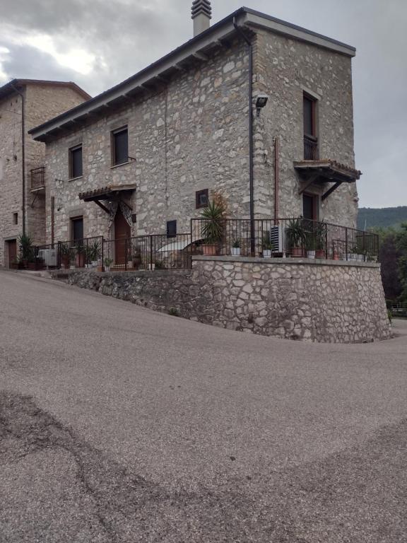 a large stone building with a stone wall at Viepri centro in Rocchette