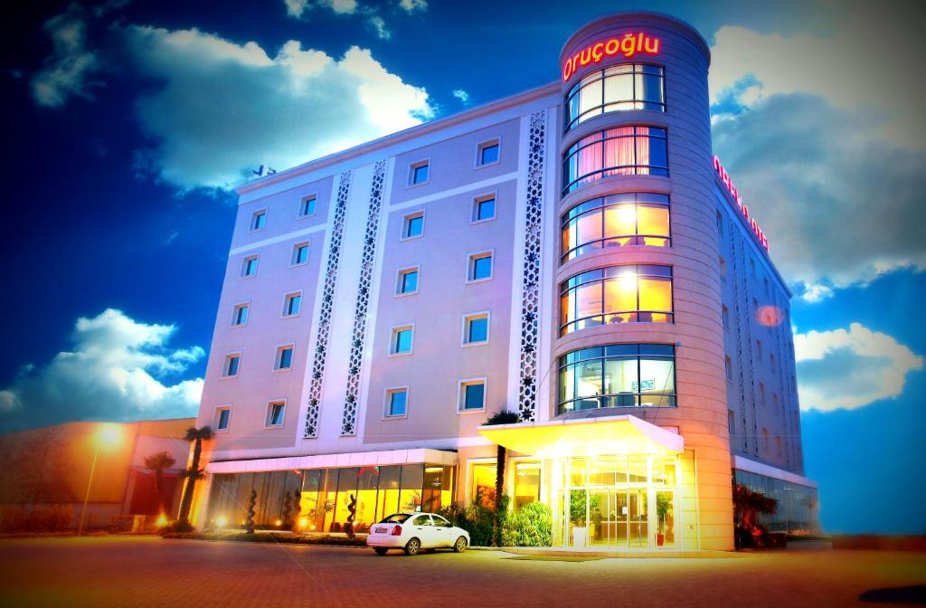 un edificio de hotel con un coche aparcado delante de él en Orucoglu Oreko Hotel, en Manisa