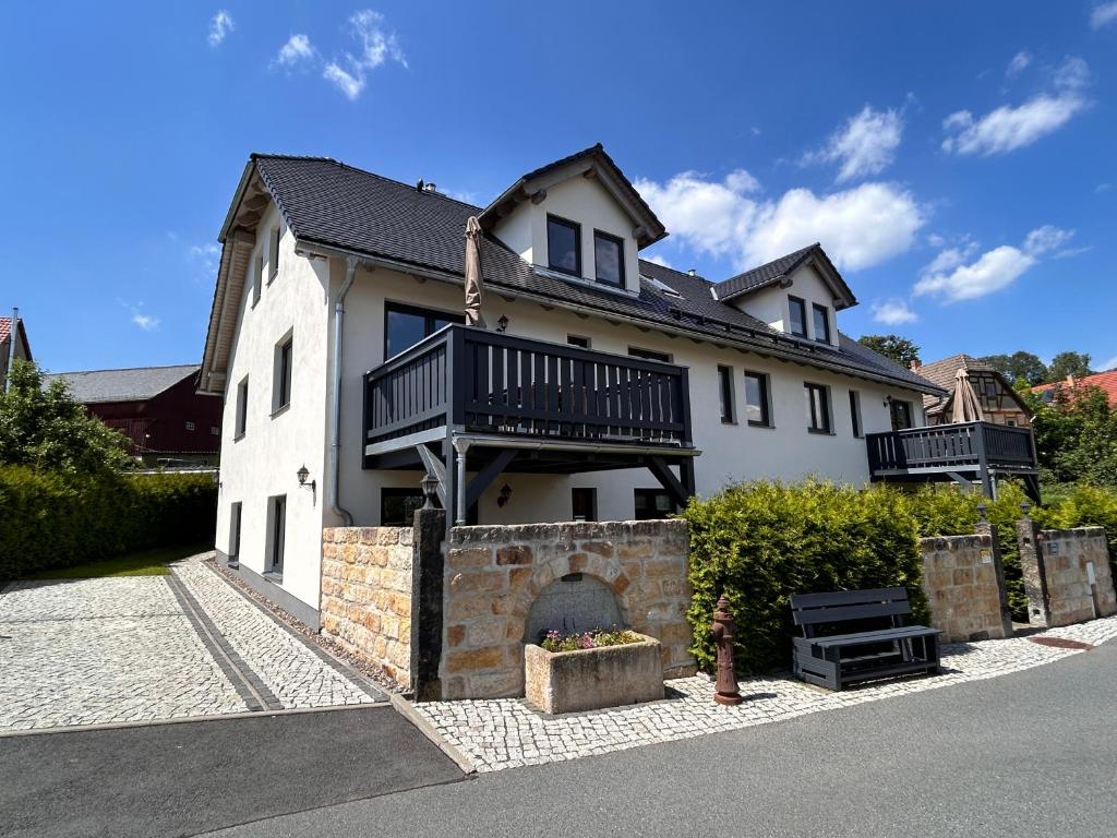 a large white house with a fireplace in front of it at Apartment in Papstdorf "Zwillingsstiege" in Kurort Gohrisch