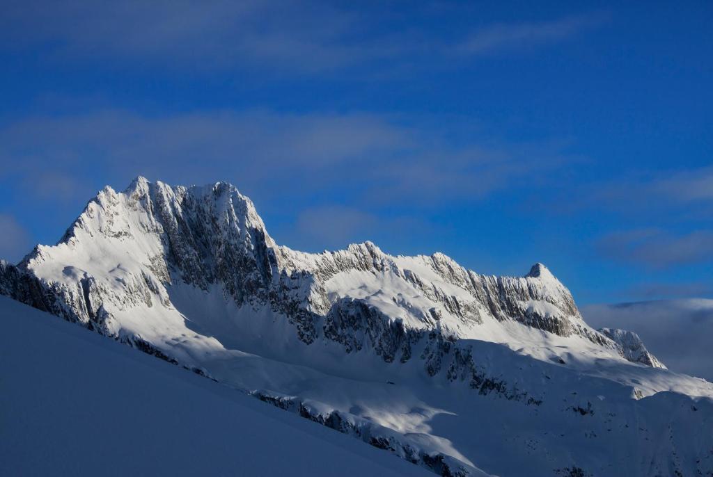 a snow covered mountain with a blue sky at Catrina Lodge in Disentis