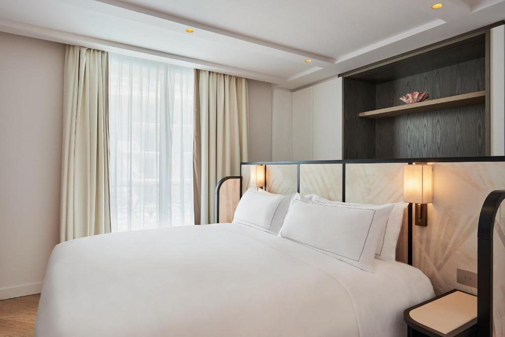 a large white bed in a hotel room at Carlton Cannes, a Regent Hotel in Cannes