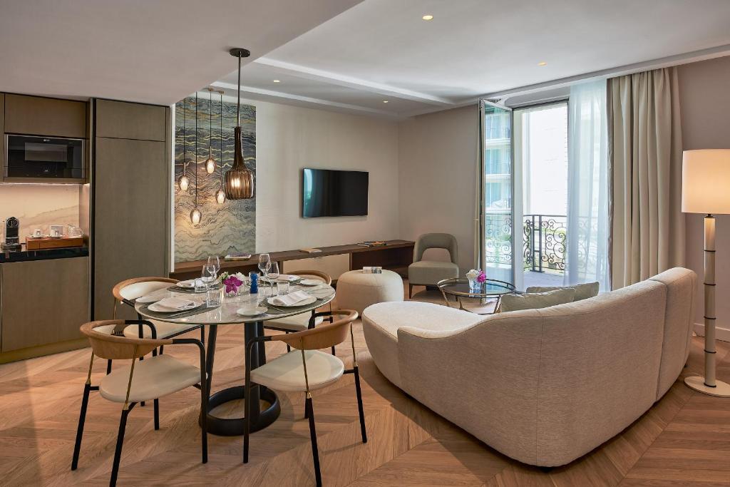 a living room with a table and chairs at Carlton Cannes, a Regent Hotel in Cannes