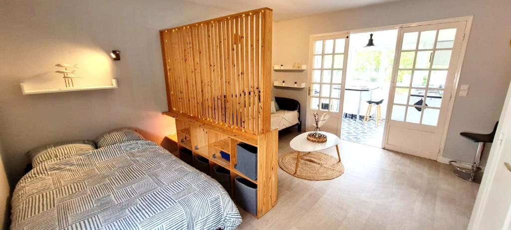 Una habitación con una cama y un sofá. en Évasion, Studio Cosy près de la Plage, en Saint-Nazaire