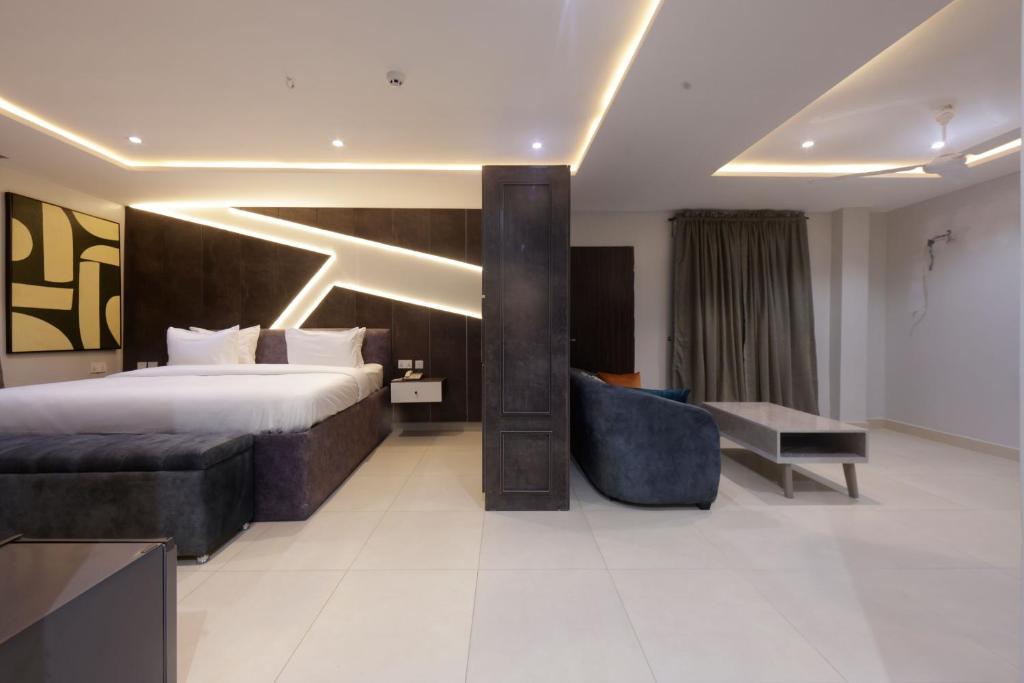 una camera d'albergo con un letto grande e un divano di House 241 ad Abuja