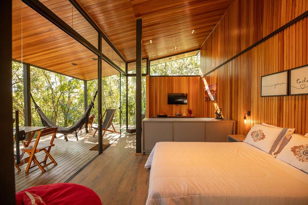 a bedroom in a house with a bed and a desk at Pousada Sitio Raizes in Siderópolis