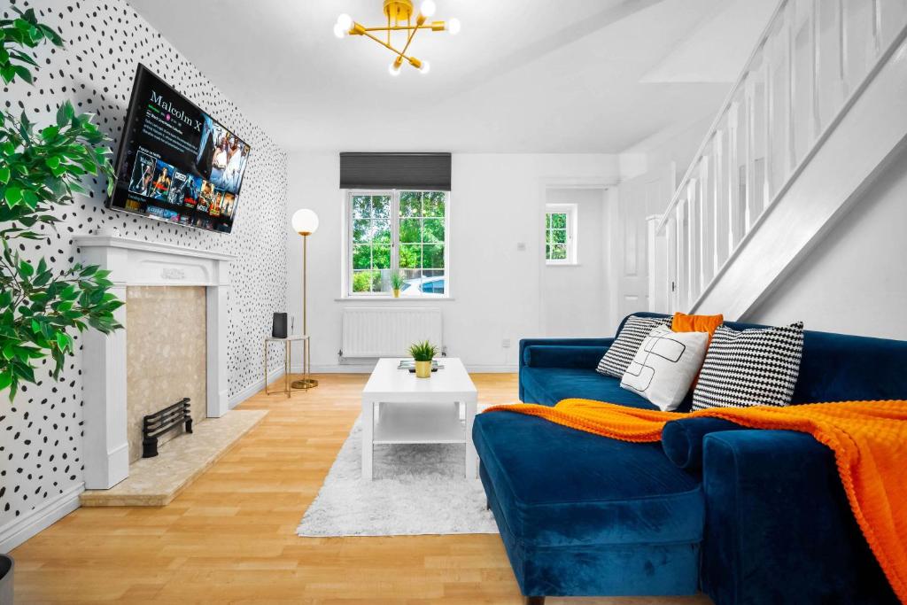 Una sala de estar con un sofá azul y una chimenea. en Stylish Two Bedroom House - Parking - Garden 55H, en Birmingham
