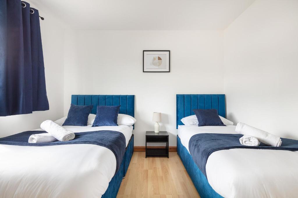 two beds in a room with blue and white at Kent Haven - 3 bed house, Games room and Parking in Kent