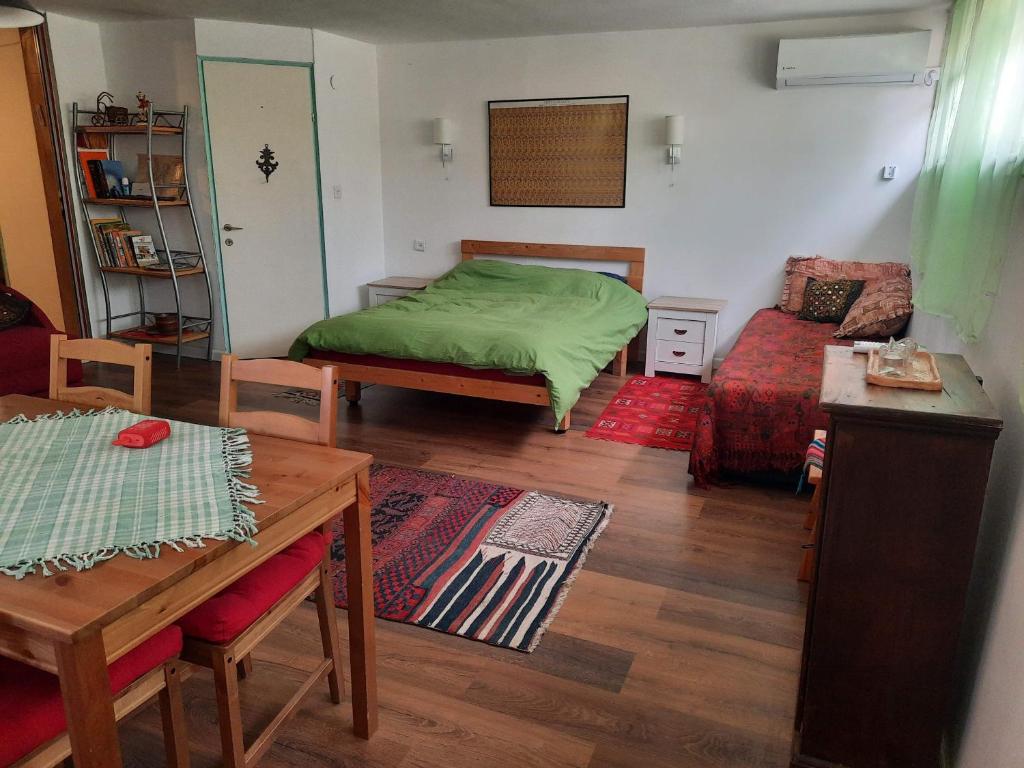 Un dormitorio con una cama verde y una mesa. en הבית הירוק - Green House, en Arad