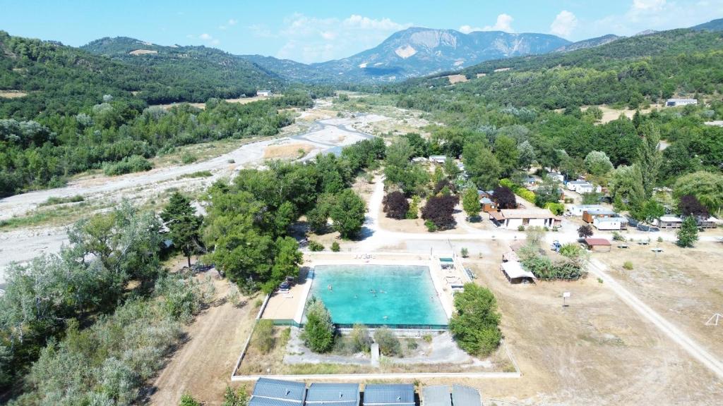 - une vue aérienne sur un complexe avec une piscine et des montagnes dans l'établissement Camping Tikayan La Célestine, à Beynes