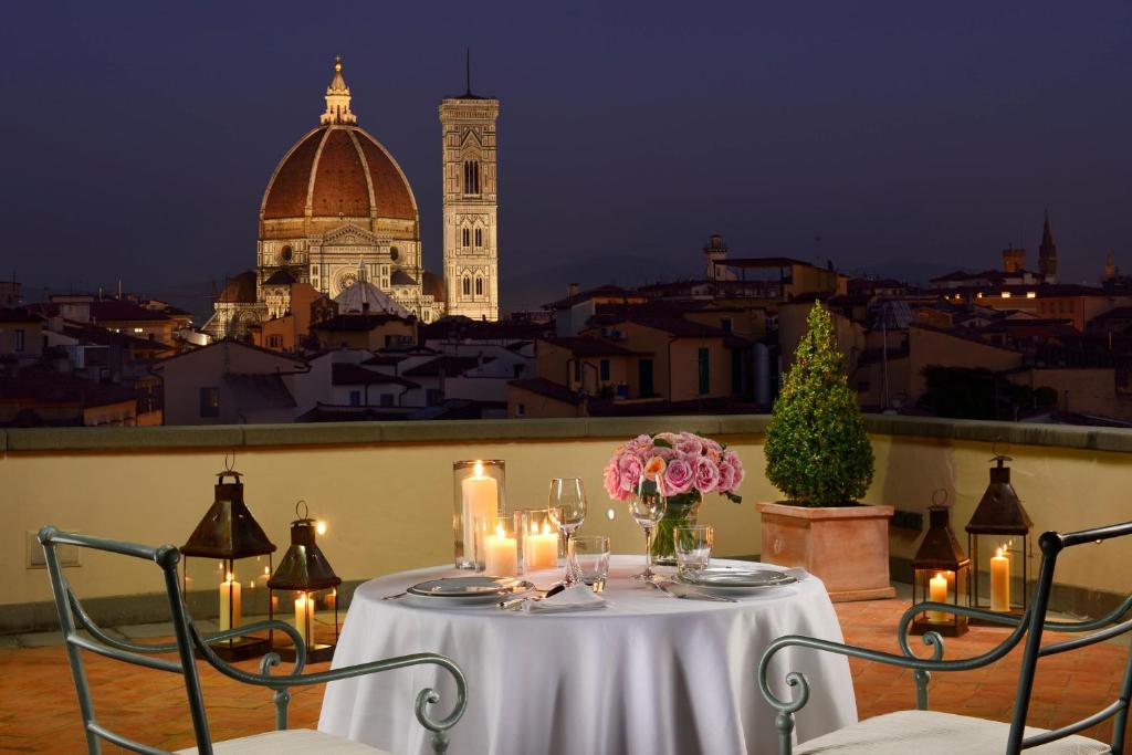 een tafel met kaarsen en bloemen op een balkon bij Santa Maria Novella - WTB Hotels in Florence