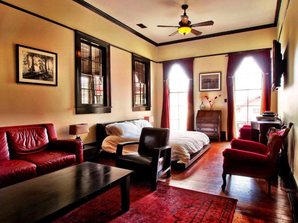 uma sala de estar com um sofá e uma cama em Royal Street Inn & Bar em Nova Orleans