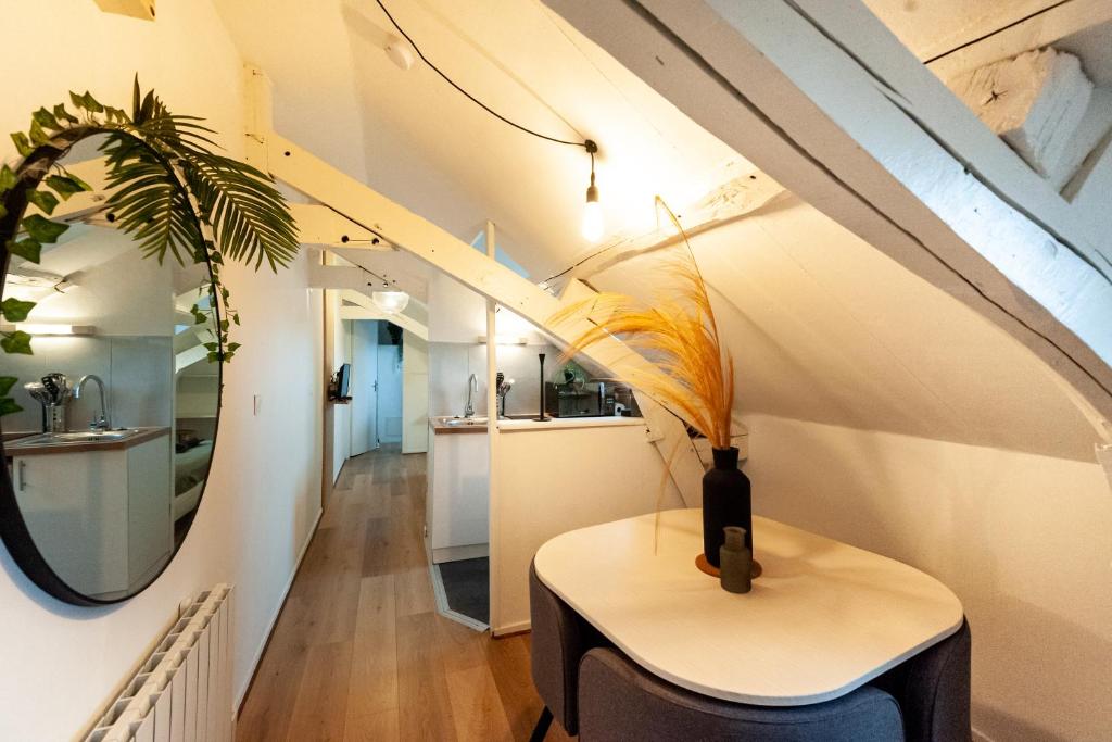 Cette chambre comprend une table et un miroir. dans l'établissement Le Loft - studio en Hypercentre - Cathédrale, à Amiens