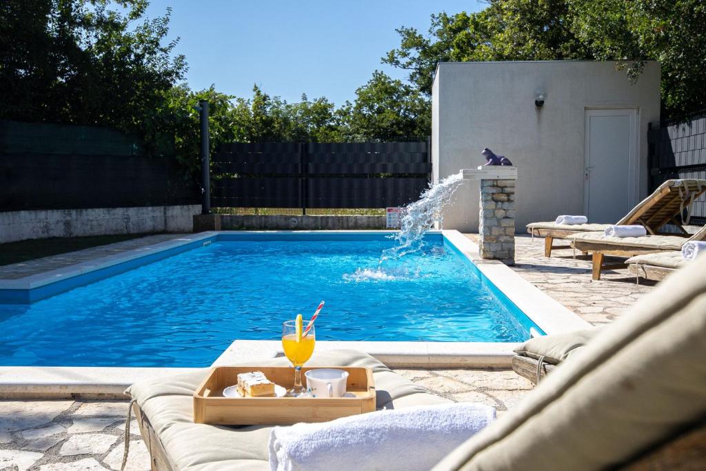a swimming pool with a fountain in a backyard at House Runjic w pool large garden and playground in Prgomet