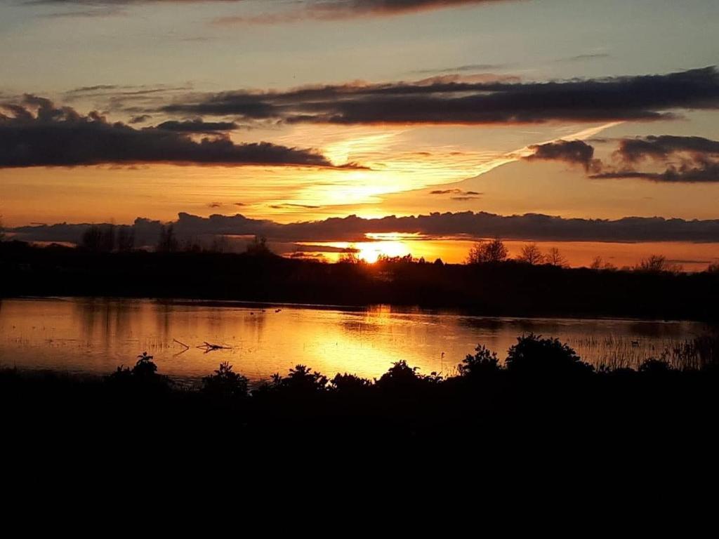 a sunset over a river with the sun setting at Glastonbury 2-Bed House Sleeps 6 & Pet Friendly in Glastonbury