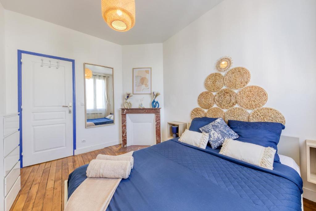 Dormitorio con cama azul y pared grande en Appartement chic proche gare de Clamart + Netflix, en Malakoff