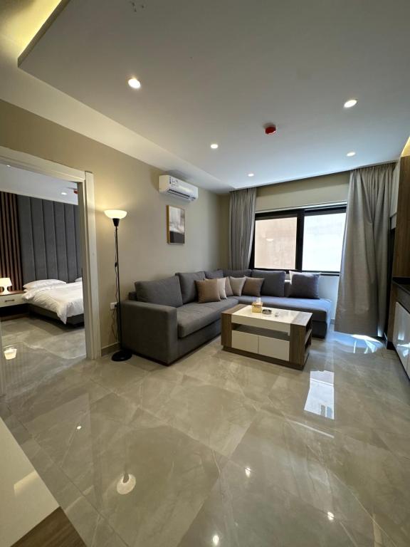 a living room with a couch and a table at Chic Apartments For Rent ave0-9 in Amman