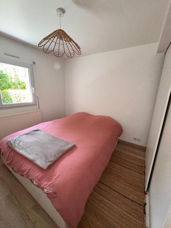 - une chambre avec un lit rouge et une fenêtre dans l'établissement Superbe appartement vannetais, à Vannes