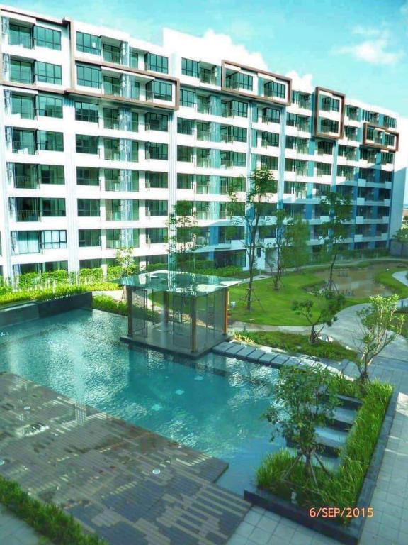 a building with a swimming pool in front of a building at Centrio Phuket C3 in Ban Rangeng