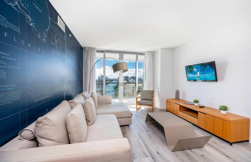 sala de estar con sofá y pared grande en 2 Bed 2 Bath With Amazing Bay View And Luxury Pool, en Hallandale Beach