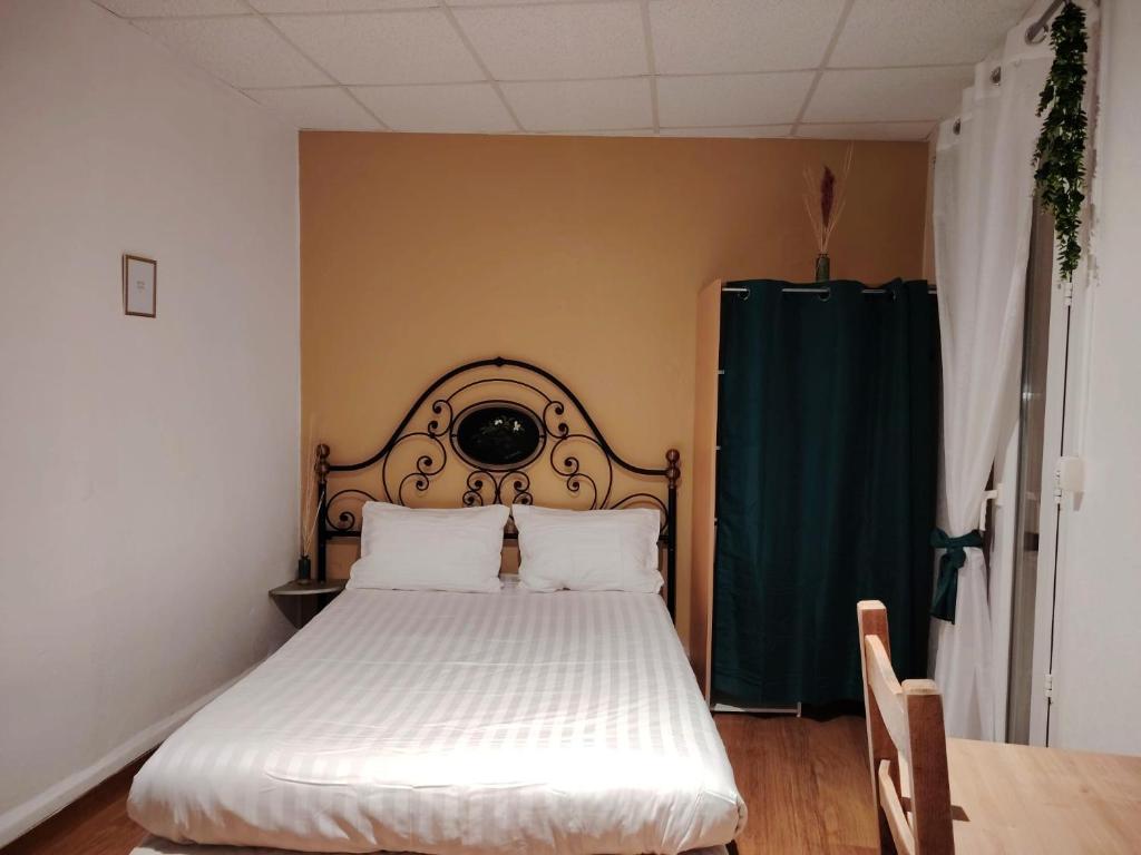 - une chambre avec un lit et un rideau vert dans l'établissement Studio N6 Appartement Hôtel Combes, à Amélie-les-Bains-Palalda
