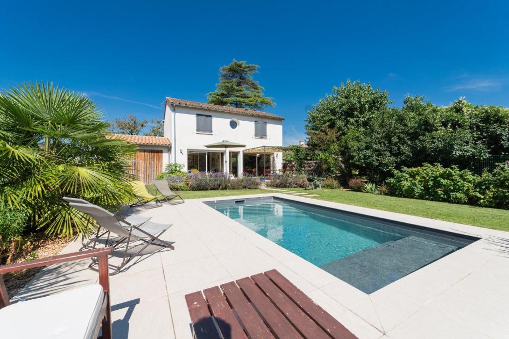 a swimming pool in front of a house at La Maison Château d'Eau : piscine pour 6/8 pers in Saint-Benoît