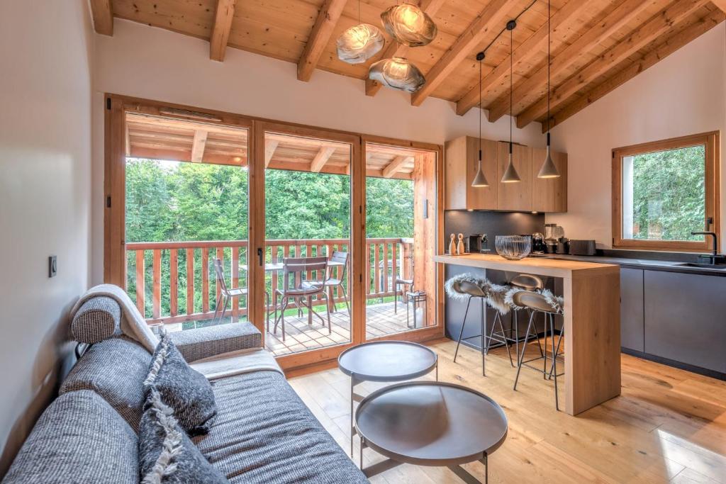un salon et une cuisine avec un canapé et une table dans l'établissement Appartement Crystal - 4 étoiles - Welkeys, à Megève