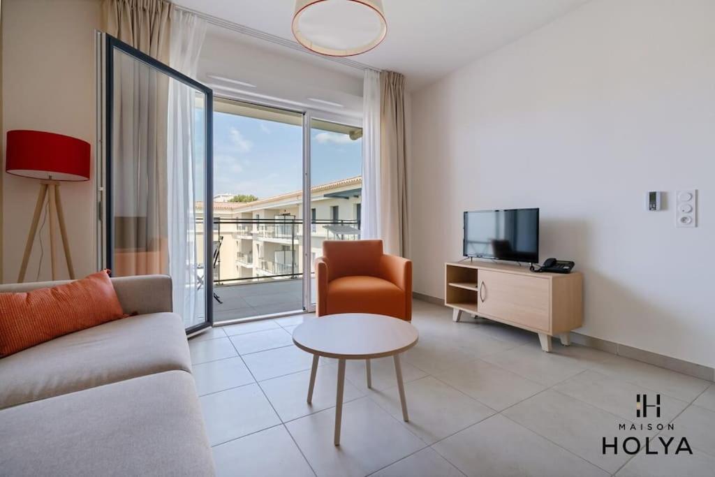 un salon avec un canapé, une télévision et une table dans l'établissement À Avignon - Le Vertige - 377B, à Avignon