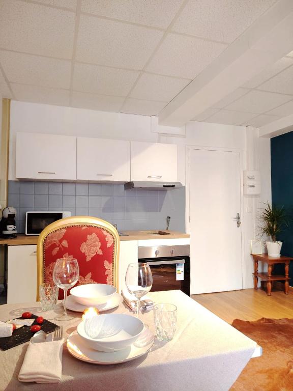 une cuisine avec une table avec des assiettes et des verres à vin dans l'établissement T2 N7 Appartement Hôtel Combes, à Amélie-les-Bains-Palalda